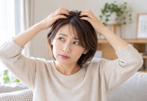 頭頂部をマッサージする女性